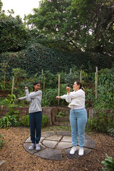 African American mom and teenage daughter stretching on stone patio in athletic wear and sneakers © WavebreakMediaMicro