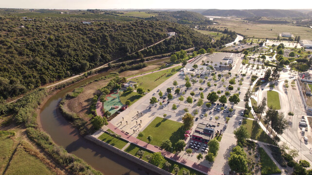 Aerial view of the parking area and green spaces along the river in Silves, Faro District, Portugal.