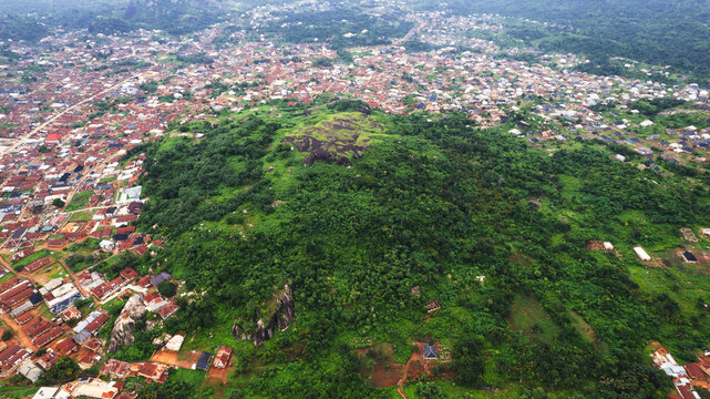 Aerial view of the lush green Idanre Hills surrounded by residential buildings and dense vegetation in Idanre, Ondo, Nigeria.