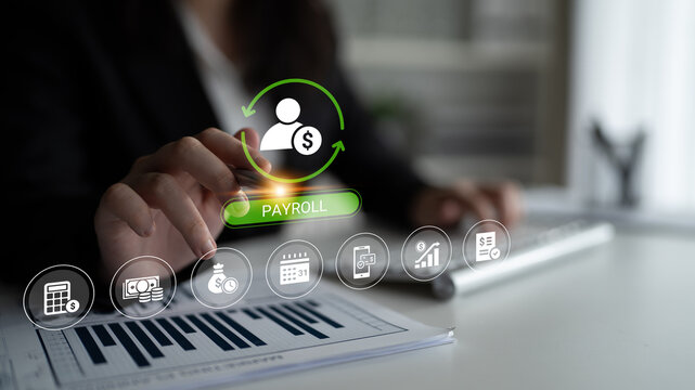 A business professional interacts with a digital payroll interface while reviewing financial documents, showcasing modern technology in a professional workspace setting. Cyphers