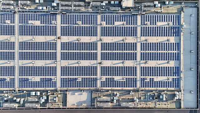 Aerial view of the solar panel array on the rooftop of Messe Frankfurt, featuring rows of photovoltaic modules and industrial ventilation units in Frankfurt am Main, Hessen, Germany.