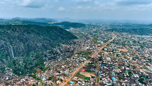 Aerial view of the rocky Dutse Alhaji hill rising above the dense urban landscape with residential rooftops and roads in Abuja, Federal Capital Territory, Nigeria.