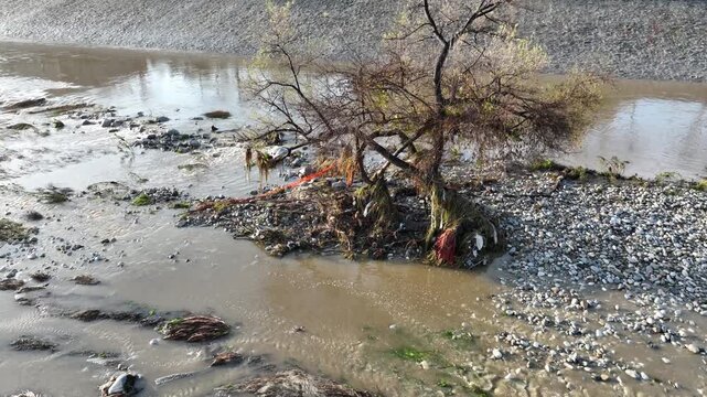 Aerial shot of flood damage and trash in the Los Angeles River after heavy rains.