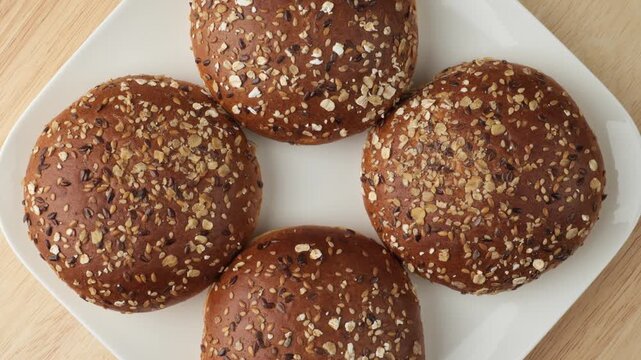 Healthy whole grain burger buns rotating on a plate