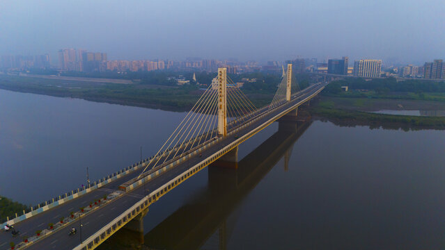 Aerial view of the modern cable-stayed bridge spanning the Tapi River with the urban skyline of Surat in the background, Surat, Gujarat, India.