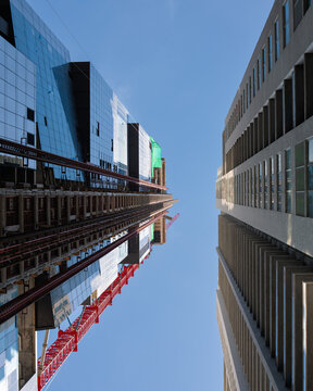 Upward View Between Modern Buildings and Construction Crane