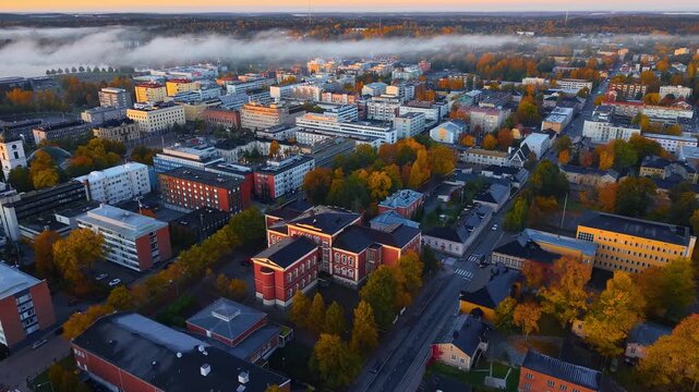4K autumn city landscape with fog in aerial view from descending drone, H&auml;meenlinna Finland. 