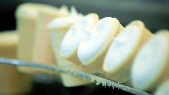 Filled cones moving production line close up. Ice cream factory food industry.