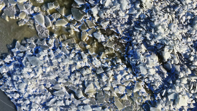 Aerial view of broken ice shards floating on the water surface in Latvia.