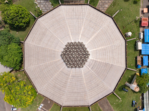Aerial view of the Nelson Rugger Sports Gym with its large octagonal roof and geometric central pattern surrounded by green lawns and trees in Araras, Sao Paulo, Brazil.