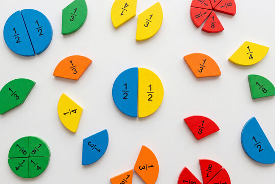 Colorful math fractions learning tools on a white surface during a math. fun education at school