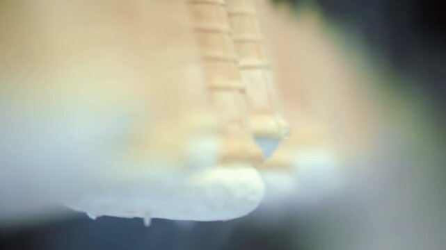 Macro cones filled ice cream moving factory line. Close up dessert production.