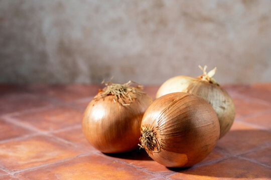 Yellow onions on a tile surface 