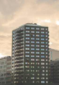 Dark modern office tower silhouetted beneath dramatic evening clouds.
