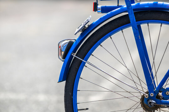 Close detail of blue bicycle rear wheel fender and reflector.
