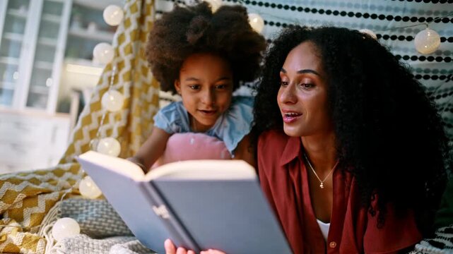 Parent reading storybook daughter cozy home tent. Multiracial family story time.