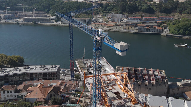Aerial view of the construction site of the new bridge over the Douro River with large blue cranes and structural steel frameworks in Porto, Porto District, Portugal.