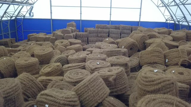 Drone flies forward past rope bales in Klin