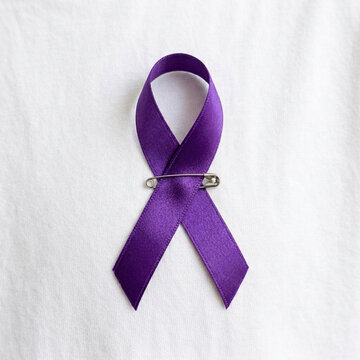 Purple Awareness Ribbon with Safety Pin on White Fabric Background