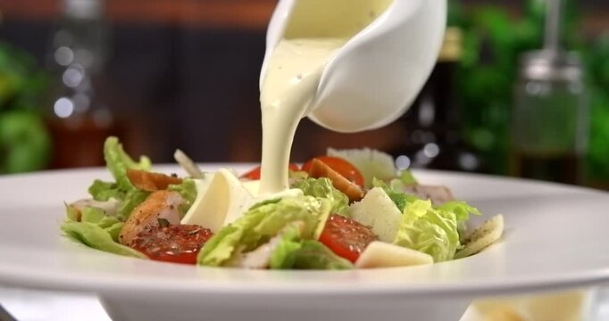 Caesar dressing pouring over fresh caesar salad slow motion 1000 fps