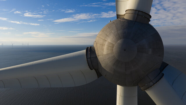Aerial view of Windmolenpark Westermeerdijk showing the hub and blades of a large wind turbine with other turbines visible in the distance over the water, Tollebeek, Flevoland, Netherlands.