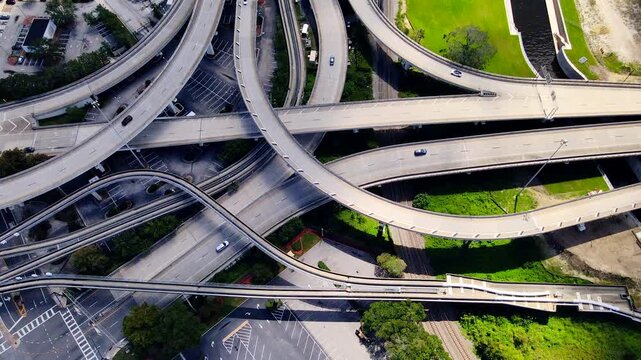 Layered overpasses form sweeping road geometry beneath moving vehicles in Jacksonville aerial video.
