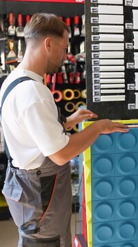 Construction worker selecting acoustic panels in hardware store