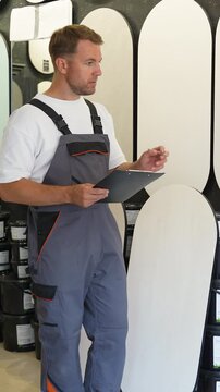 Warehouse worker managing inventory and writing on clipboard
