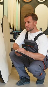 Warehouse worker taking inventory notes on clipboard