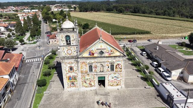 V&aacute;lega church showcasing colorful azulejo tiles on its exterior facade under clear sky