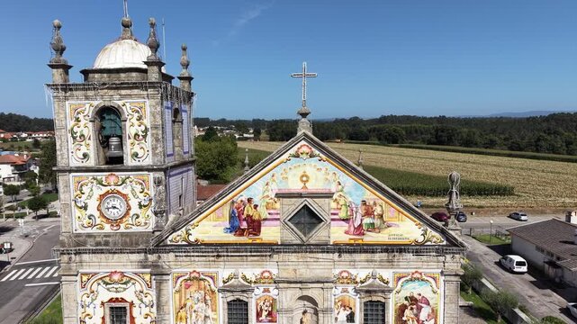 V&aacute;lega church showcasing colorful azulejo tiles on its exterior facade under clear sky