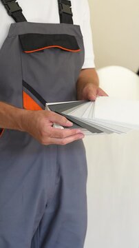Professional painter holding a gray color swatch palette