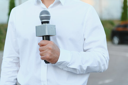 Journalist holding microphone reporting live tv news broadcast