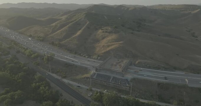 Aerial view of freeway with overpass bridge in hazy hills