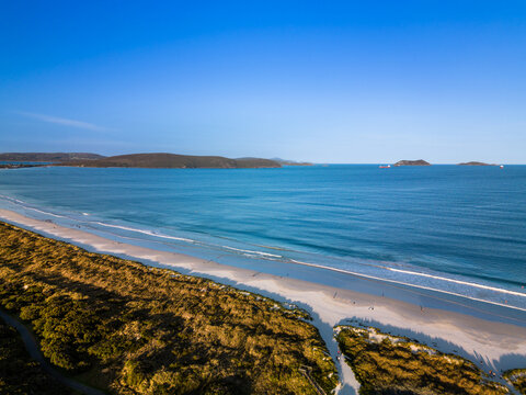 Aerial view of Middleton Beach featuring golden sand, turquoise ocean waves, and coastal vegetation under a clear blue sky in Albany, WA, Australia.