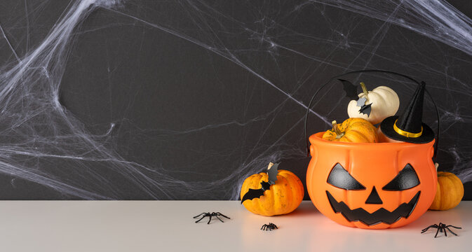Happy Halloween pumpkin bucket with jack-o'-lantern face, mini pumpkins, bats and spider decor