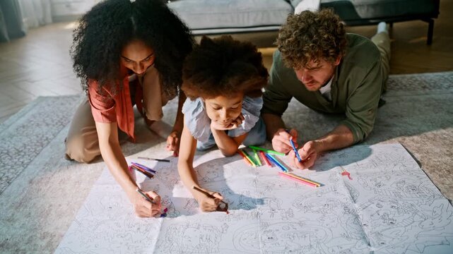 Family coloring giant poster living room floor. Mother father daughter home art.