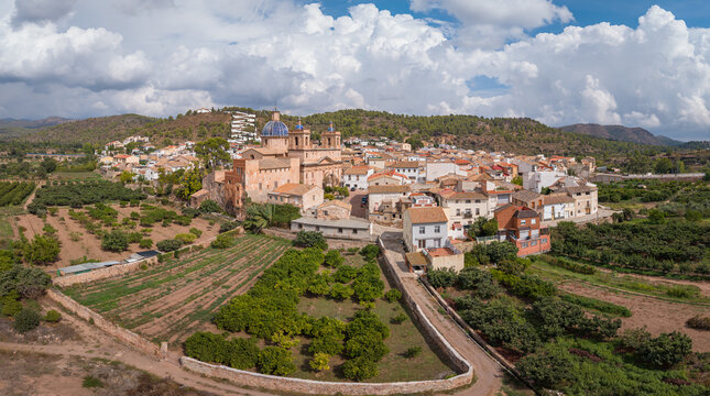 Aerial view of the Palace of Sot de Ferrer and the historic village with stone houses, orange groves, and rolling hills in Sot de Ferrer, Comunidad Valenciana, Spain.