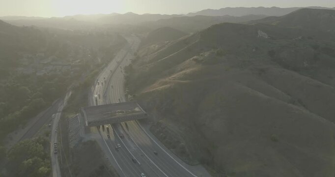 Aerial view of freeway with overpass bridge in hazy hills