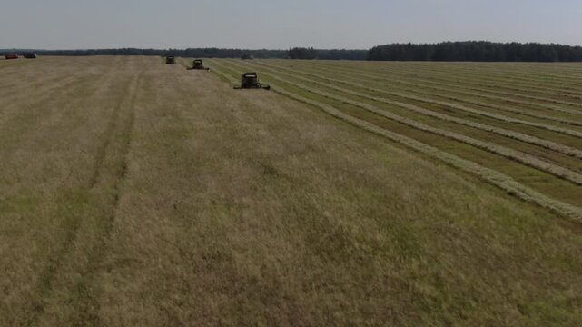 Drone flies forward toward working combines, D-Log