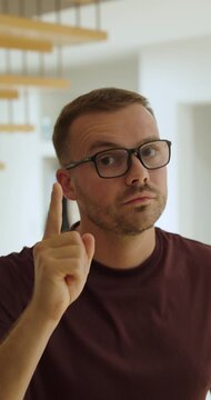 Man wearing glasses raises a finger while scolding, representing disapproval, warnings and assertive communication