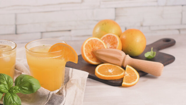 Fresh orange juice with sliced citrus fruits and wooden reamer