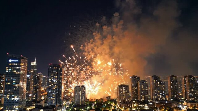 Fireworks display exploding over urban city skyline at night