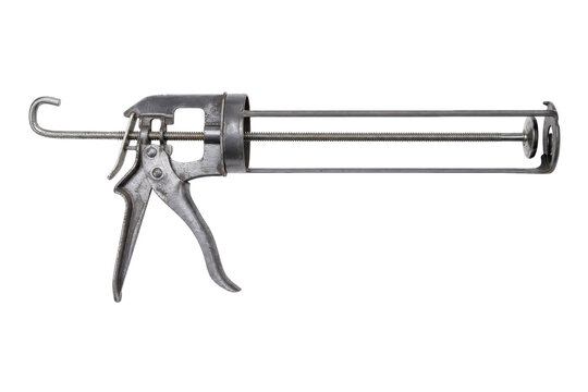 Old metal caulking gun with a trigger handle and long threaded rod, isolated on a clean white background