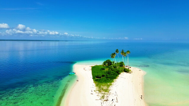 Aerial view of Manimbora Beach with white sand, turquoise water, and palm trees Batu Putih, East Kalimantan, Indonesia.