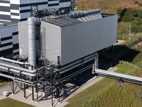 Aerial view of a modern waste disposal facility featuring industrial metal structures, complex piping systems, and steel framework in Gdansk, Poland.