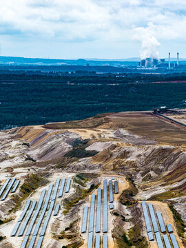 Aerial view of the Hambach open-pit mine featuring rows of solar panels on reclaimed land with a power plant in the background in Elsdorf, Nordrhein-Westfalen, Germany.