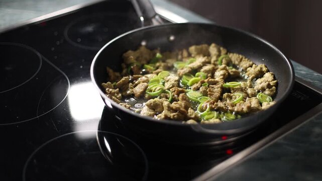 Soy pieces and leeks fry in a pan on a stove