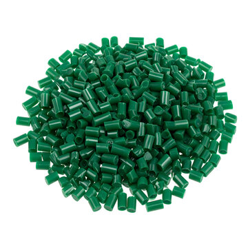 Green plastic pellets isolated in a round pile representing industrial manufacturing raw material supply for injection molding processes&nbsp;&nbsp;