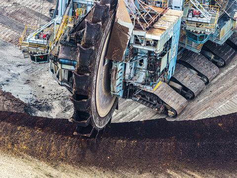 Aerial view of the massive bucket-wheel excavator digging into the earth at the Garzweiler surface mine in Juchen, North Rhine-Westphalia, Germany.